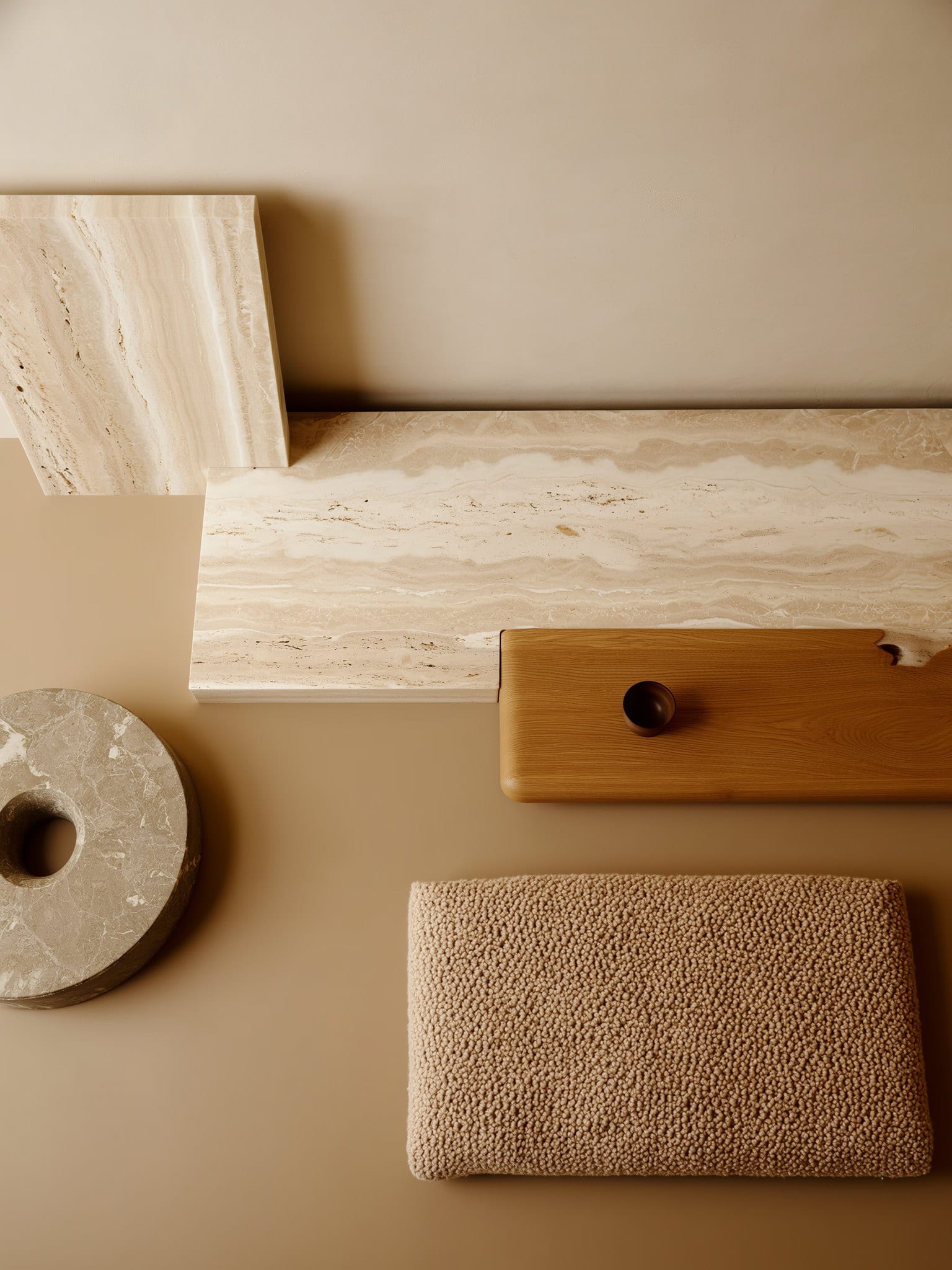 Layered material palette in a studio interior: rough stone, sage plaster, warm wood, and boucle